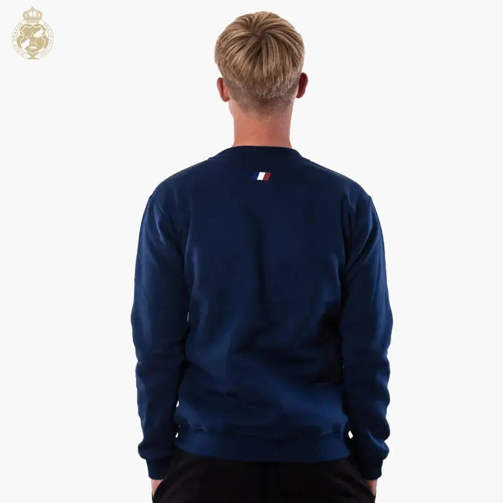Person wearing a navy blue sweatshirt with a small logo on the back against a white background